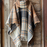 Klasiskas rūtis karameļi brūnos/pelēkos/baltos toņos indiāņu piegriezuma garais aitas vilnas pončo ar kapuci un bārkstīm