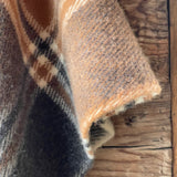 Klasiskas rūtis karameļi brūnos/pelēkos/baltos toņos indiāņu piegriezuma garais aitas vilnas pončo ar kapuci un bārkstīm