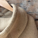 Karameļu brūna toņa garais 100% vilnas pončo ar kapuci un bārkstīm